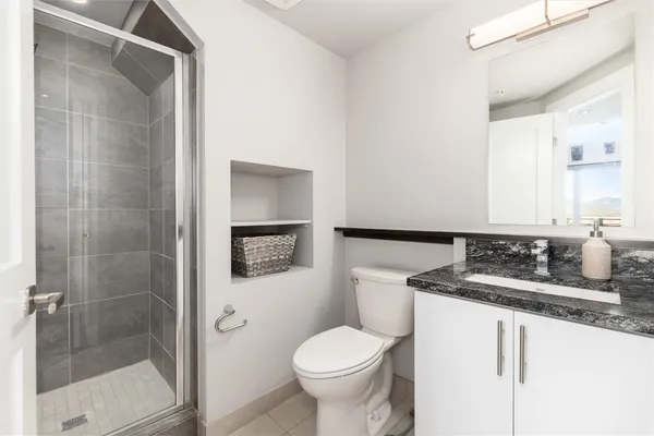 a bathroom with a granite countertop sink toilet and shower