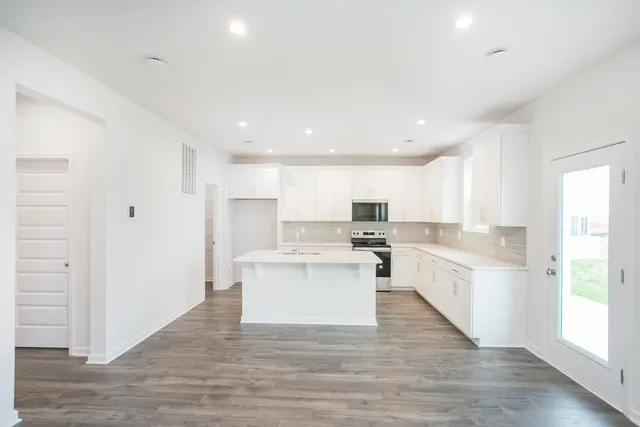 a view of kitchen with wooden floor and electronic appliances
