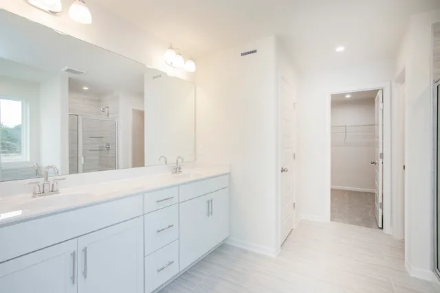 a bathroom with a double vanity sink and mirror