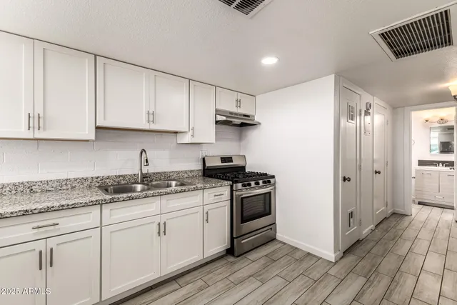 a kitchen with a refrigerator sink and cabinets