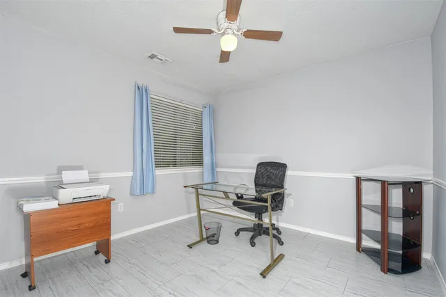 a view of a workspace with furniture and a window