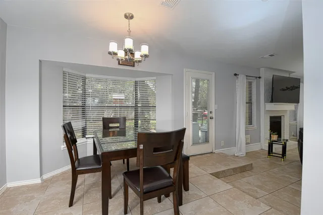a dining room with furniture a chandelier and window