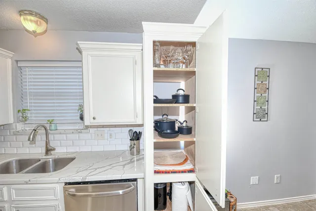 a kitchen with a sink and a stove with wooden floor