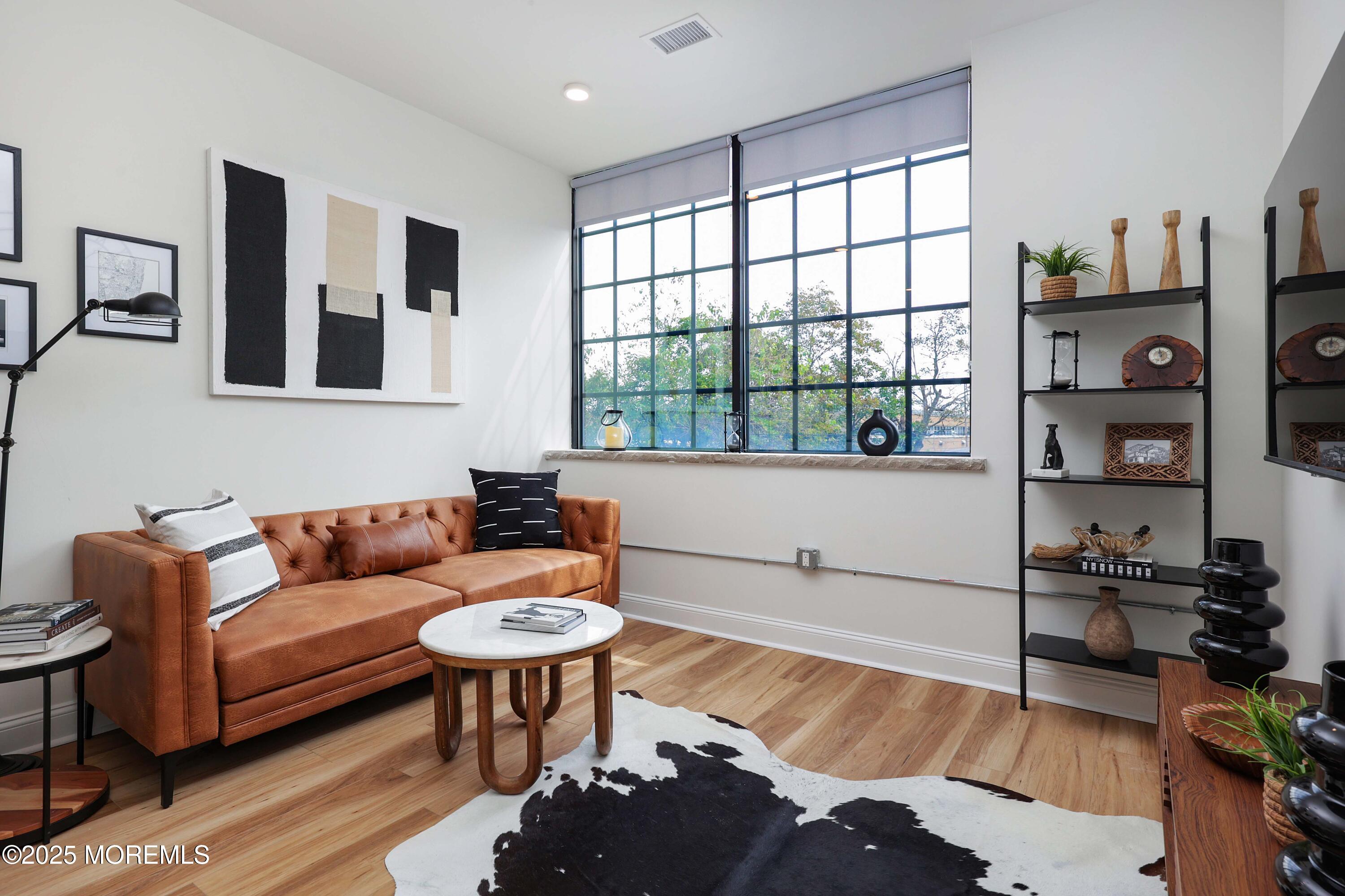 a living room with furniture a rug and a window