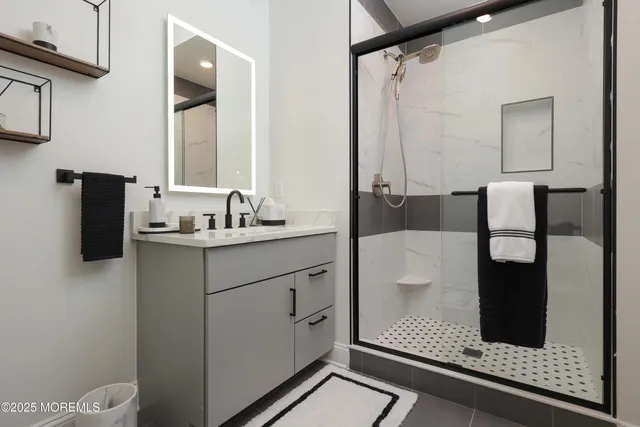 a bathroom with a shower sink and mirror