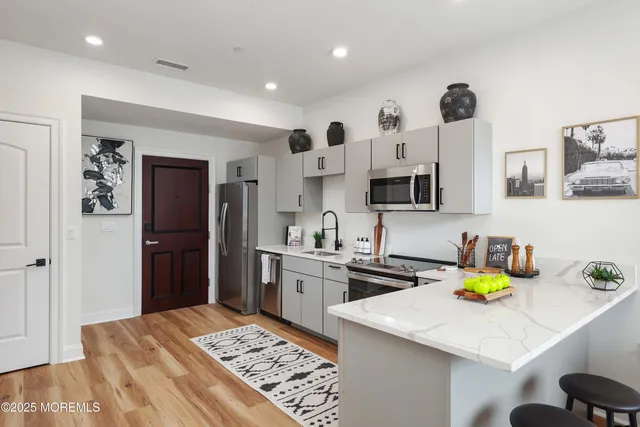 a kitchen with stainless steel appliances a stove refrigerator sink and cabinets