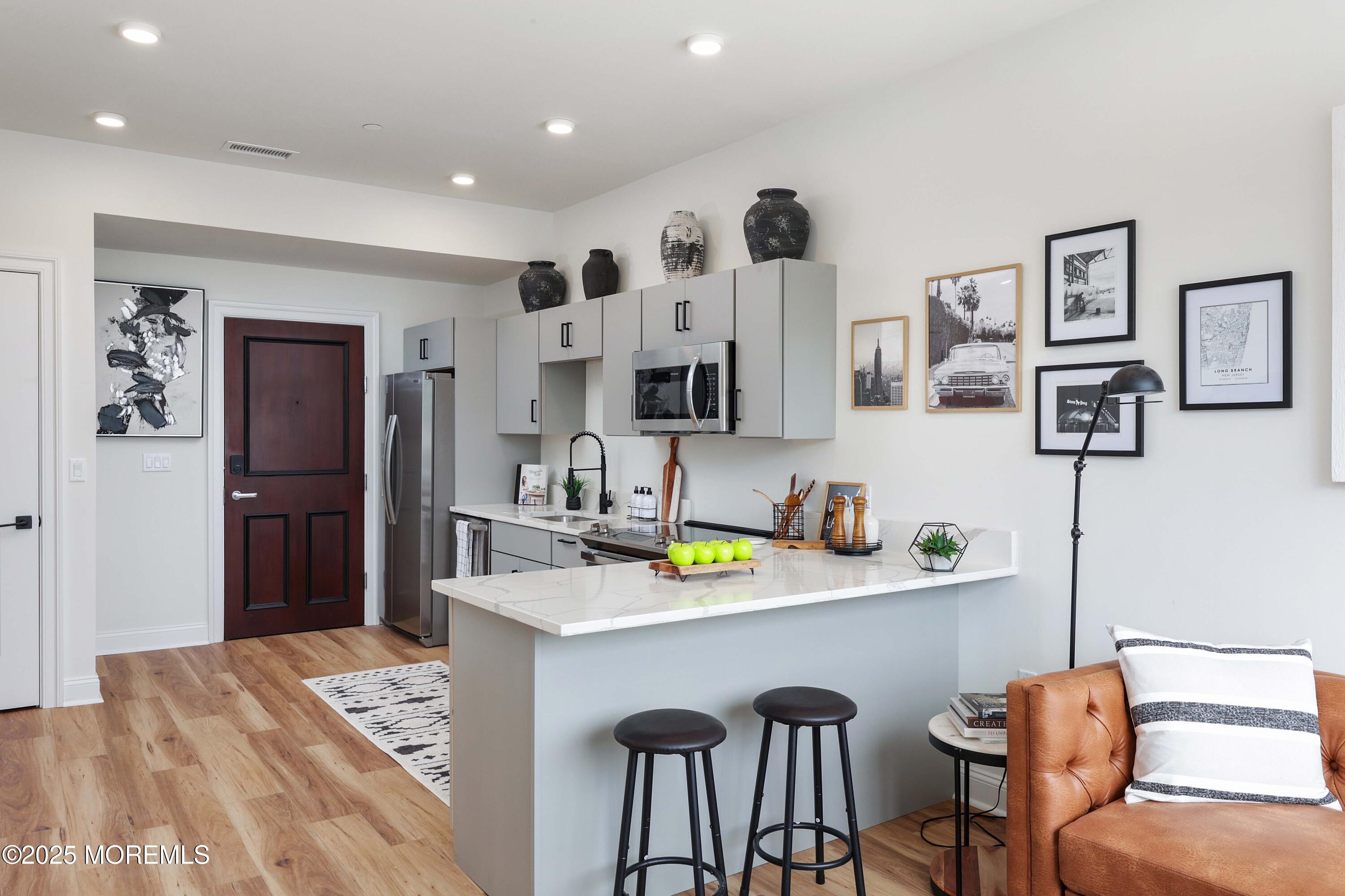 179 Chelsea Avenue, Unit 203 Long Branch, NJ 07740 - Photo 7 of 14 a kitchen with stainless steel appliances kitchen island granite countertop a refrigerator and a sink