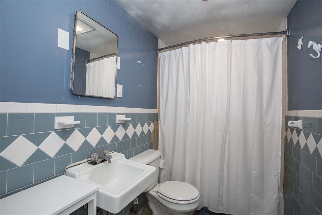 175 Summer Street Norwell, MA 02061 - Photo 13 of 29 a bathroom with a sink a toilet and shower curtain