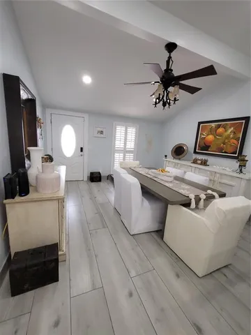 a large white kitchen with stainless steel appliances kitchen island a large counter top a stove a chimney a sink and a refrigerator