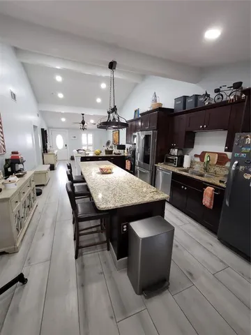 a kitchen with granite countertop a sink dishwasher stove and cabinets