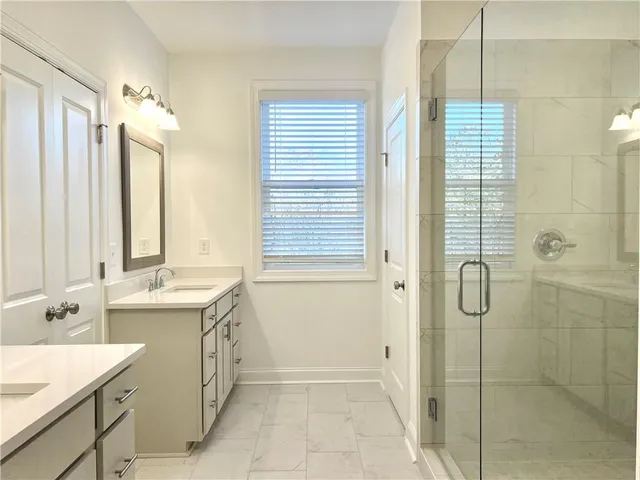 a bathroom with a double vanity sink mirror and shower