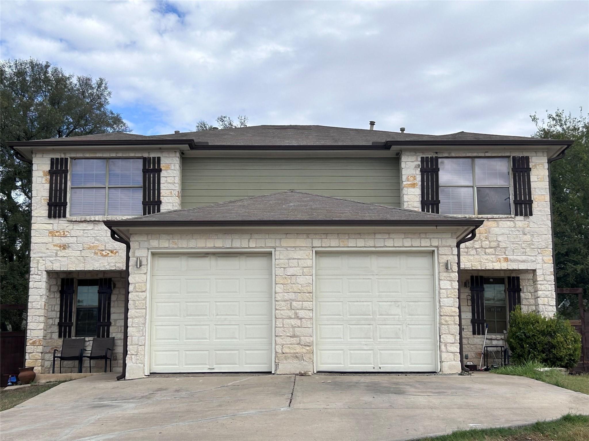 5708 Spring Meadow Road, Unit B Austin, TX 78744 - Photo 1 of 23 Traditional home with stone siding, concrete driveway, a garage, and roof with shingles