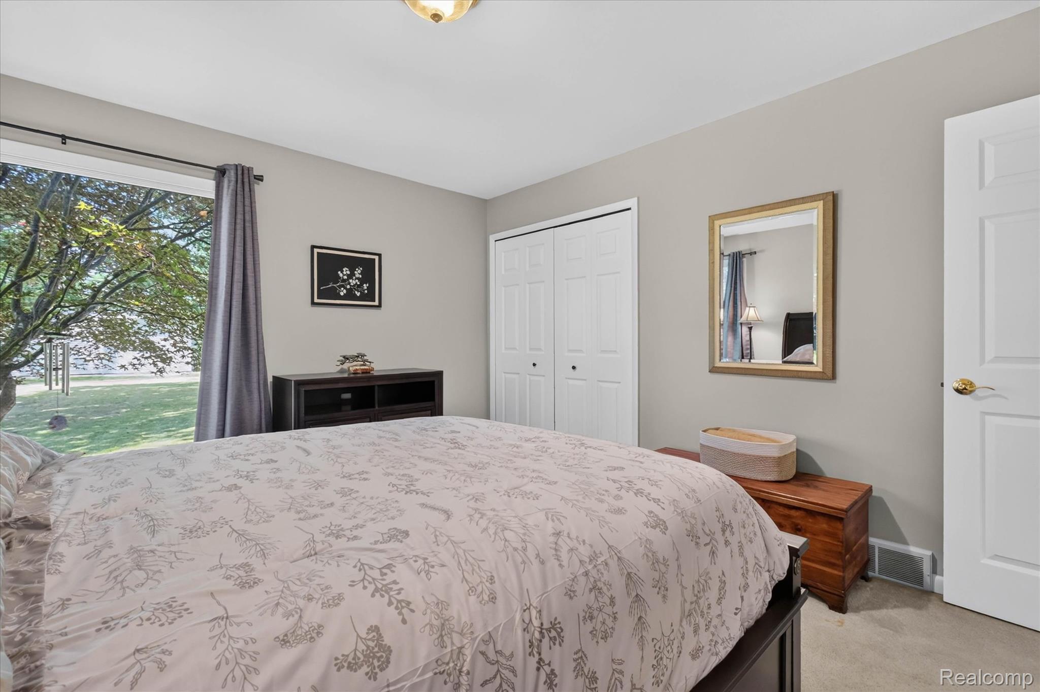 4037 Chilson Road Howell, MI 48843 - Photo 24 of 69 Spacious room with a large window, light gray walls, built-in bi-fold closet doors, and carpeted flooring