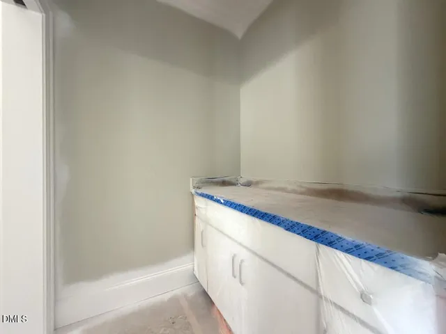 a bathroom with a granite countertop sink and white cabinets