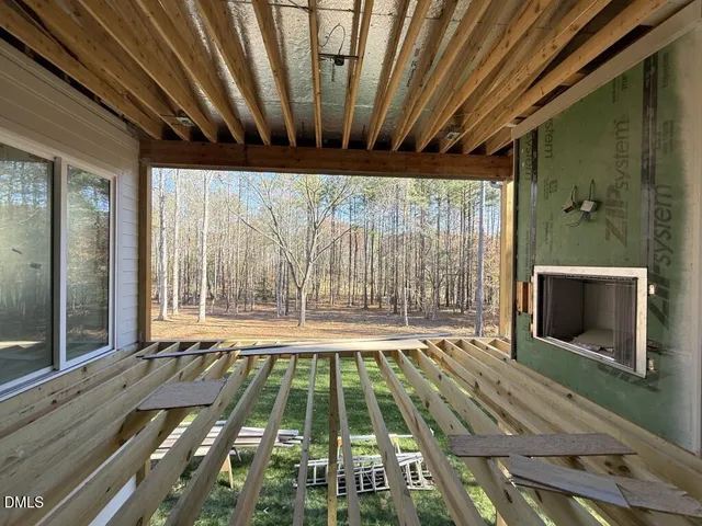 a view of an empty room with a fireplace and a window