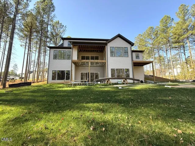 a view of a house with a big yard and large trees