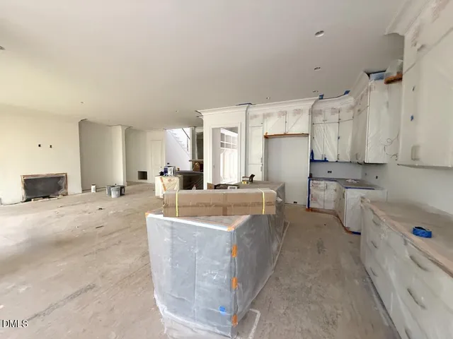 a large white kitchen with cabinets a sink and a stove