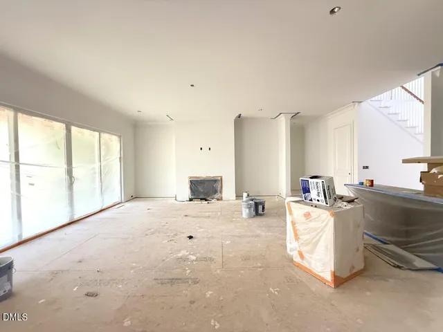 a large white room with a large window and kitchen view