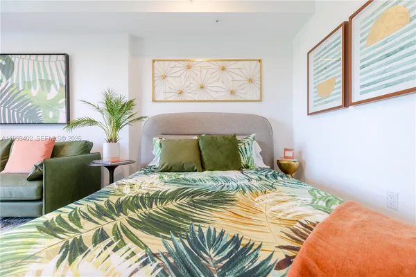 a bedroom with a bed and a painting on the wall