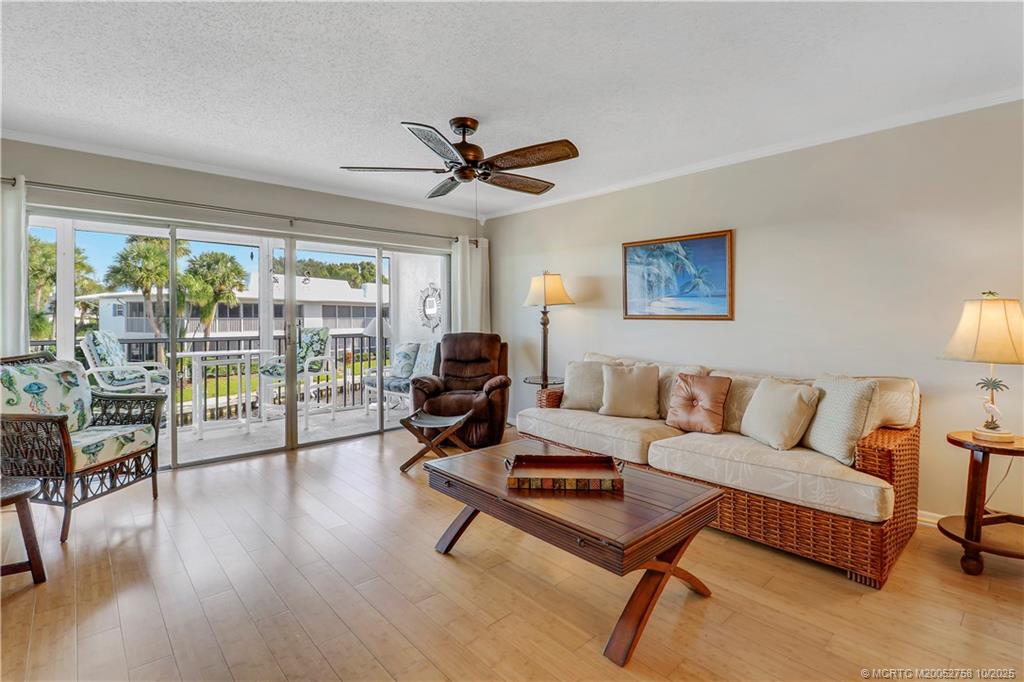 1866 Southwest Palm City Road, Unit 204 Stuart, FL 34994 - Photo 13 of 56 a living room with furniture a ceiling fan and a large window