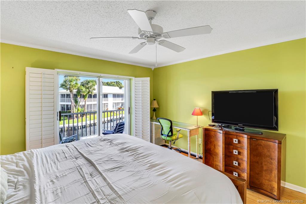 1866 Southwest Palm City Road, Unit 204 Stuart, FL 34994 - Photo 19 of 56 a bedroom with a bed and a flat screen tv