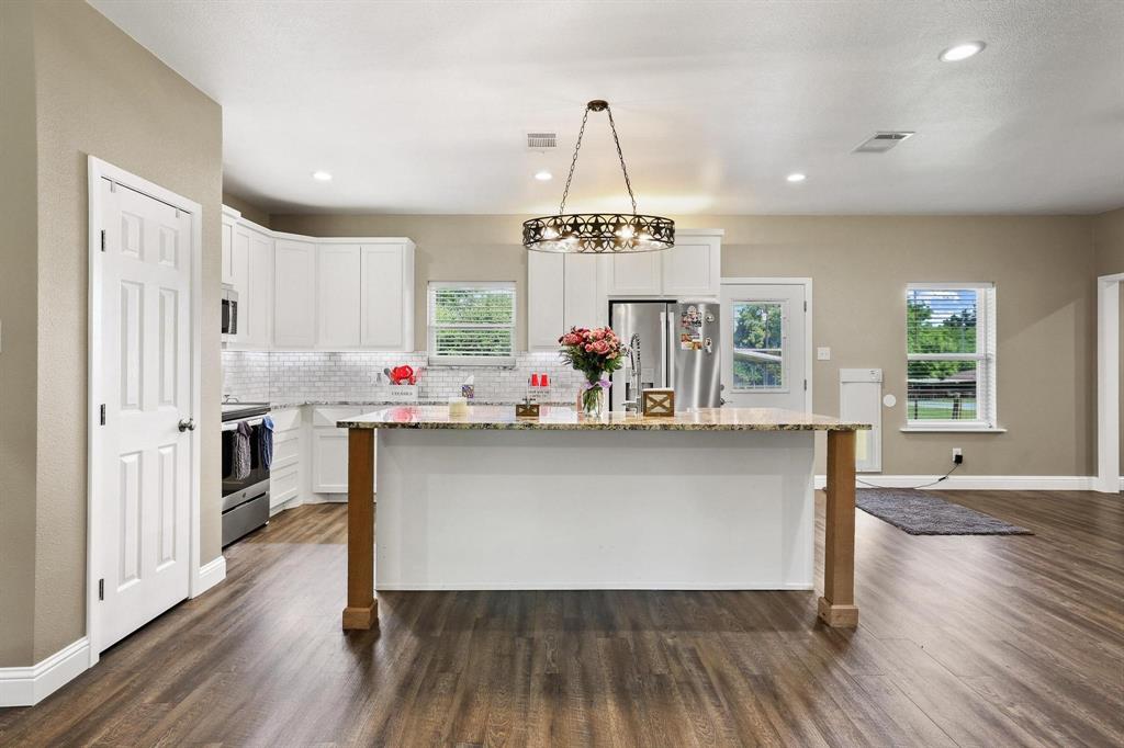 2658 Oak Ridge Road Denison, TX 75021 - Photo 10 of 37 a living room with kitchen island granite countertop wooden floor and stainless steel appliances