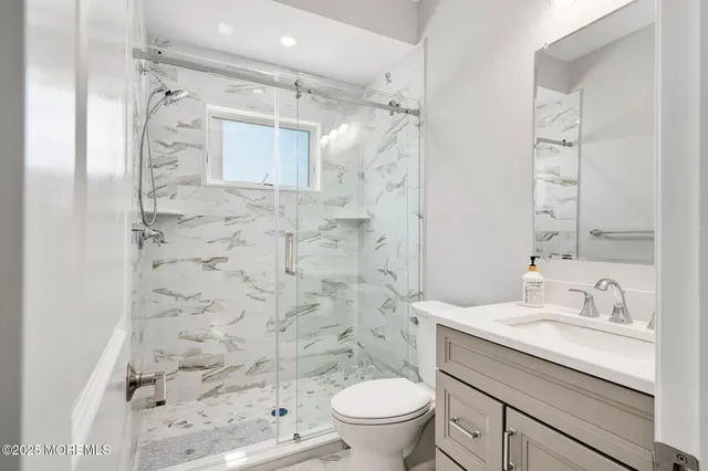 a bathroom with a granite countertop sink a toilet and shower