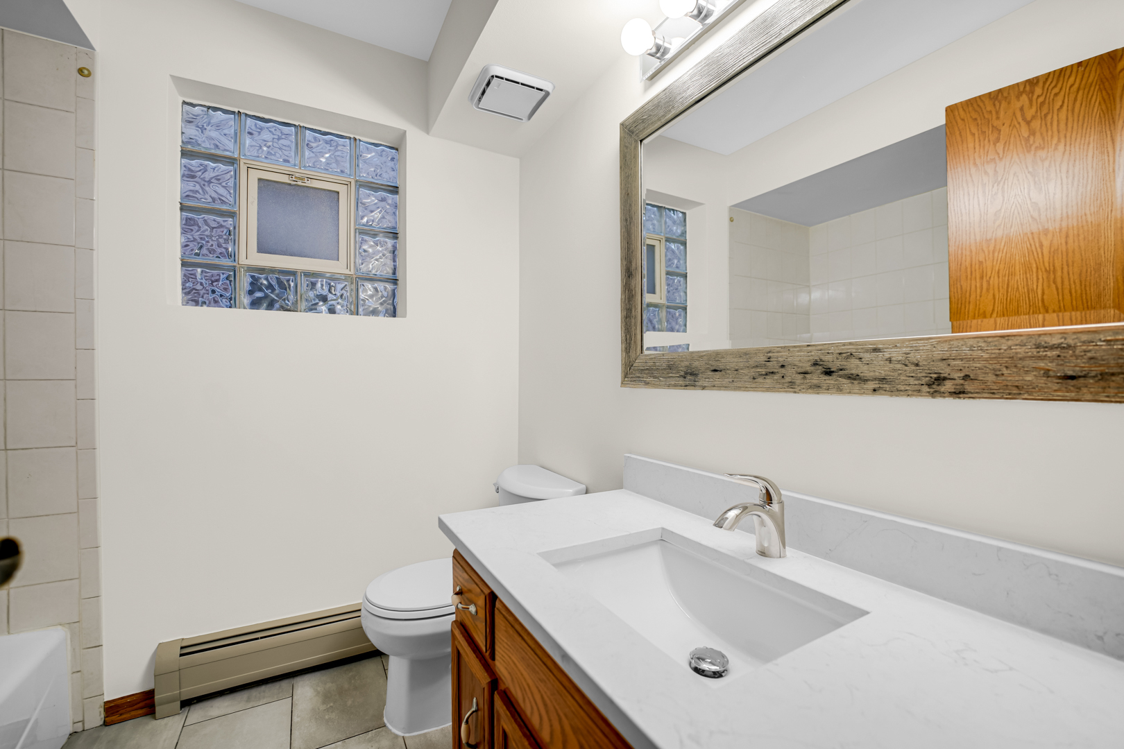 5324 Long Avenue, Unit 1 Chicago, IL 60638 - Photo 11 of 18 a bathroom with a sink a toilet and mirror