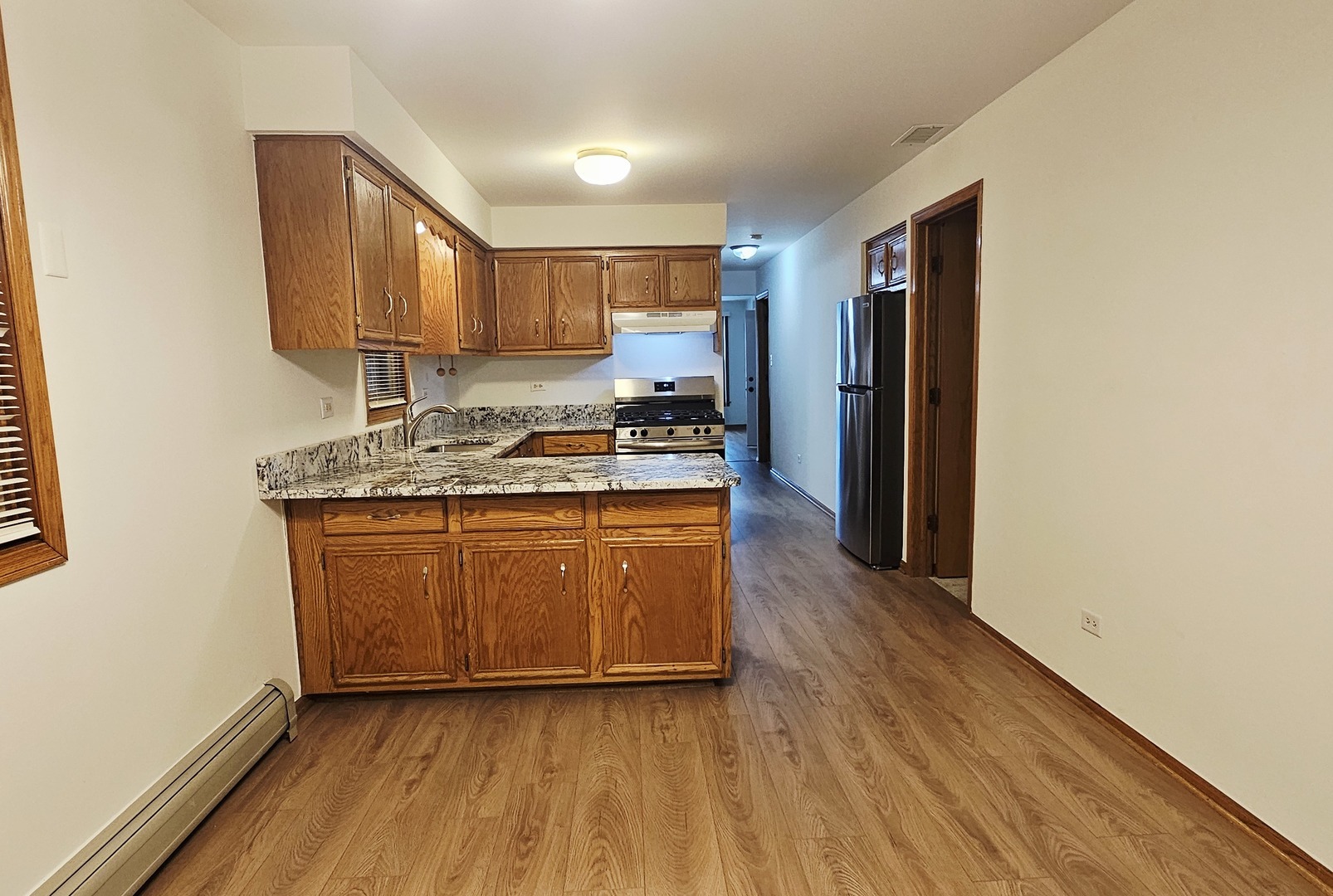 5324 Long Avenue, Unit 1 Chicago, IL 60638 - Photo 9 of 18 a kitchen with wooden floors and a sink