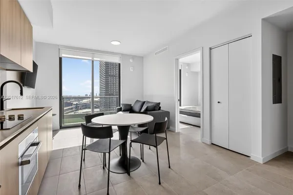 a open kitchen with stainless steel appliances granite countertop a stove top oven a sink a refrigerator and white cabinets
