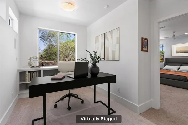 a view of a workspace with furniture and a window