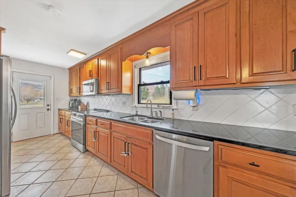 a kitchen with stainless steel appliances granite countertop a refrigerator and a stove
