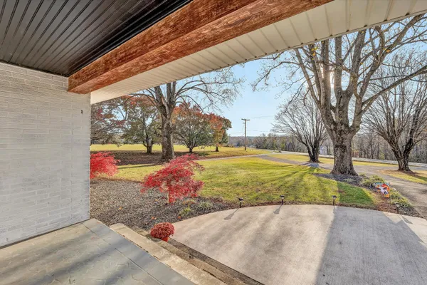 a view of a hallway with wooden floor and furniture