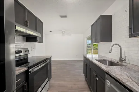a kitchen with stainless steel appliances granite countertop a sink stove and refrigerator