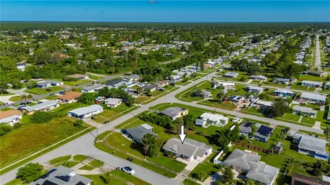an aerial view of residential houses with outdoor space and trees