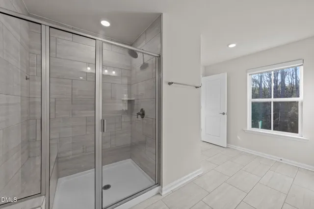 a bathroom with a shower and a glass door