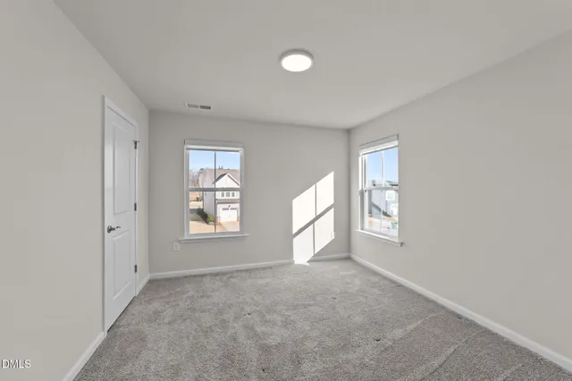 an empty room with windows and closet