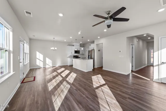 a view of a big room with wooden floor and a kitchen