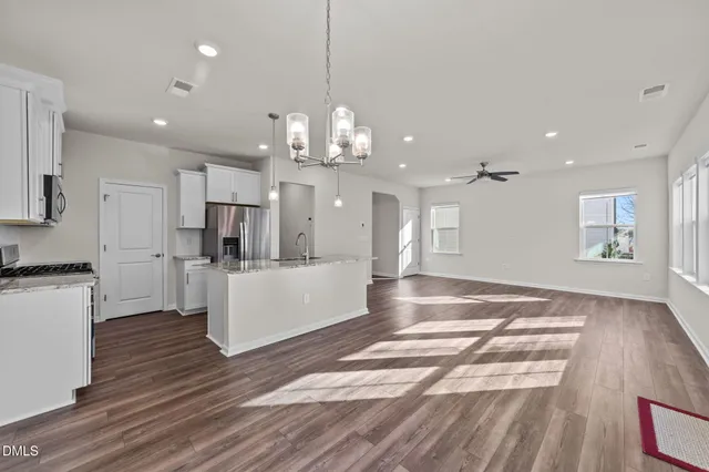 a view of a kitchen with refrigerator microwave and wooden floor