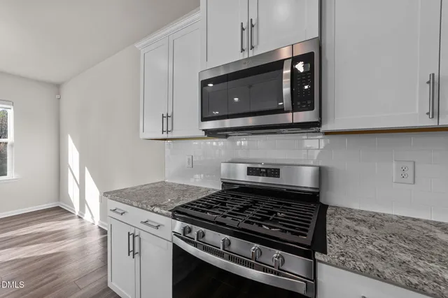 a kitchen with microwave cabinets and stove top oven
