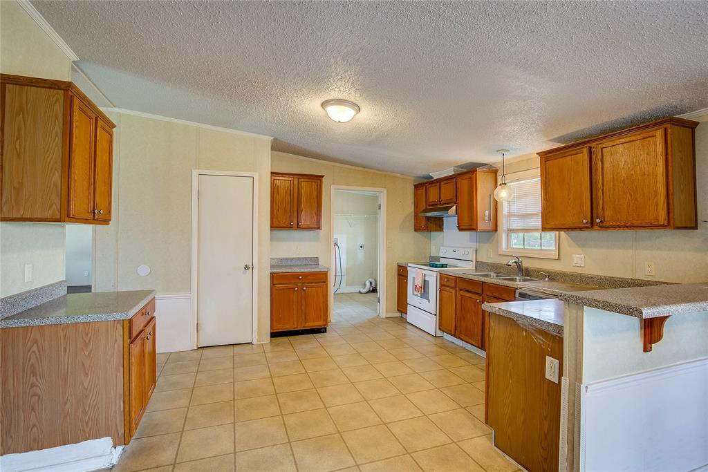 3077 Pecan Court Princeton, TX 75407 - Photo 14 of 37 a large kitchen with stainless steel appliances granite countertop a stove a sink dishwasher and a refrigerator