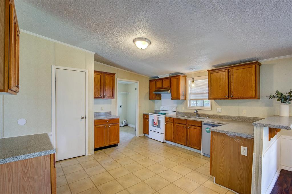 3077 Pecan Court Princeton, TX 75407 - Photo 15 of 37 a kitchen with stainless steel appliances granite countertop a stove and a sink