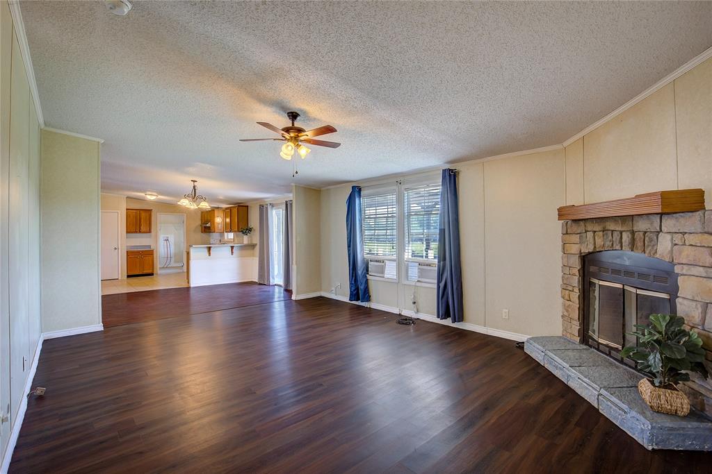 3077 Pecan Court Princeton, TX 75407 - Photo 18 of 37 a view of an empty room with wooden floor and a fireplace