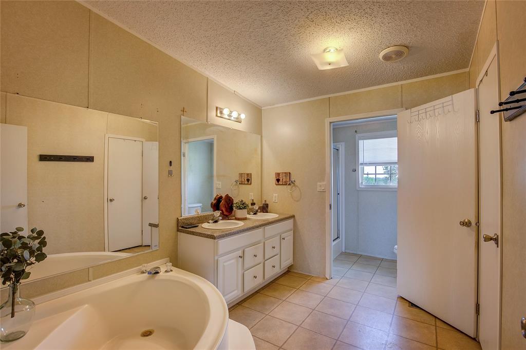 3077 Pecan Court Princeton, TX 75407 - Photo 22 of 37 a spacious bathroom with a double vanity sink a mirror and a bathtub