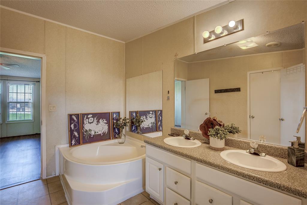 3077 Pecan Court Princeton, TX 75407 - Photo 23 of 37 a en suite bathroom with a double vanity sink and a mirror