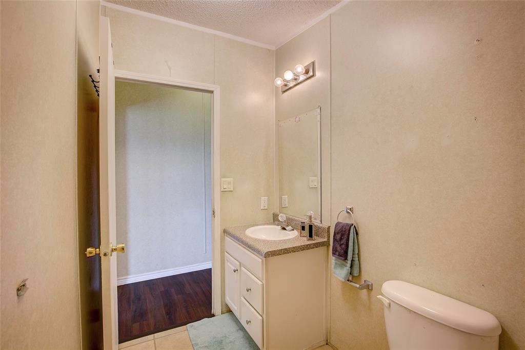 3077 Pecan Court Princeton, TX 75407 - Photo 30 of 37 a bathroom with a sink a toilet and mirror