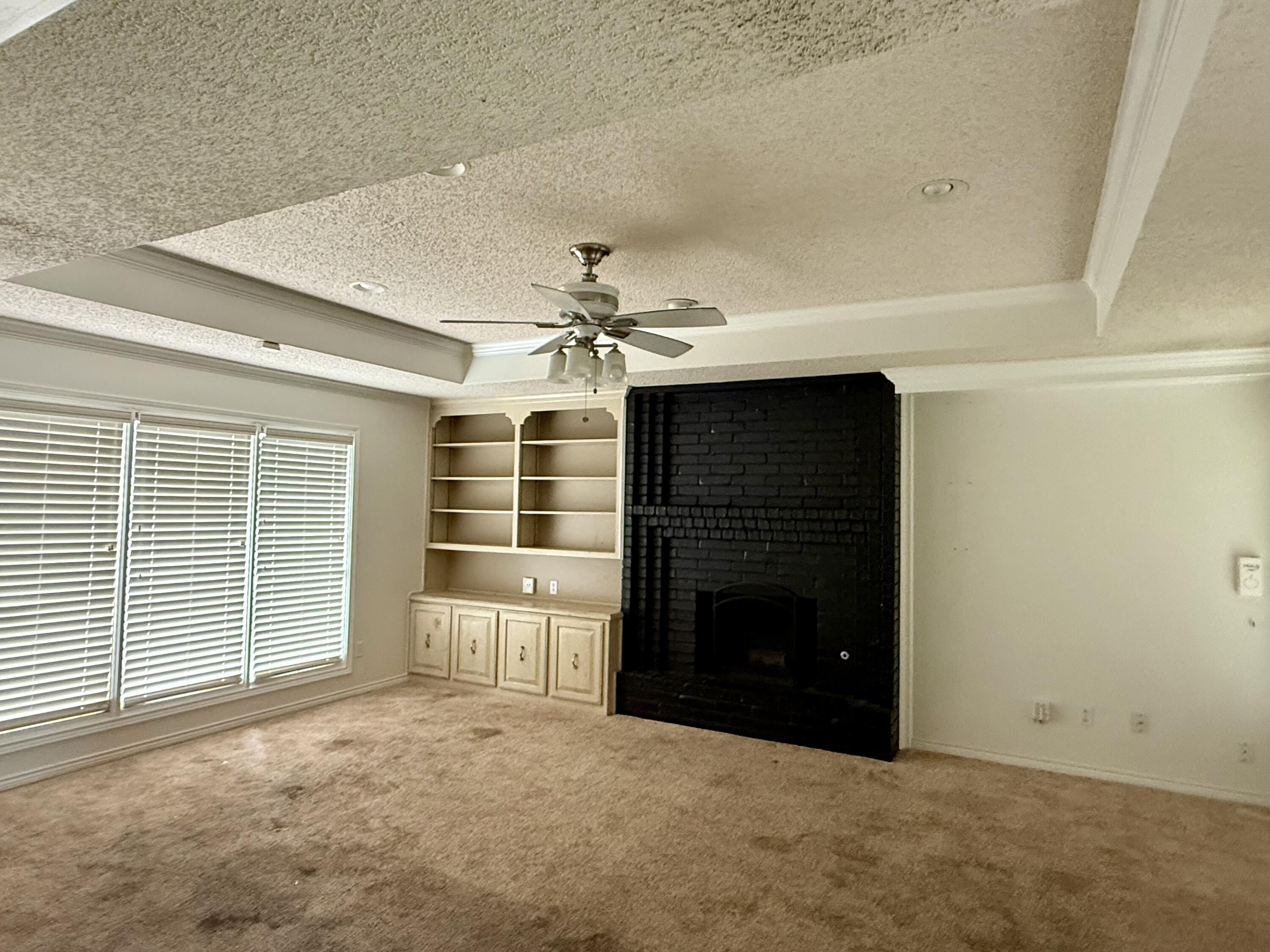 5912 74th Street Lubbock, TX 79424 - Photo 2 of 12 a view of an empty room with a fireplace and a window