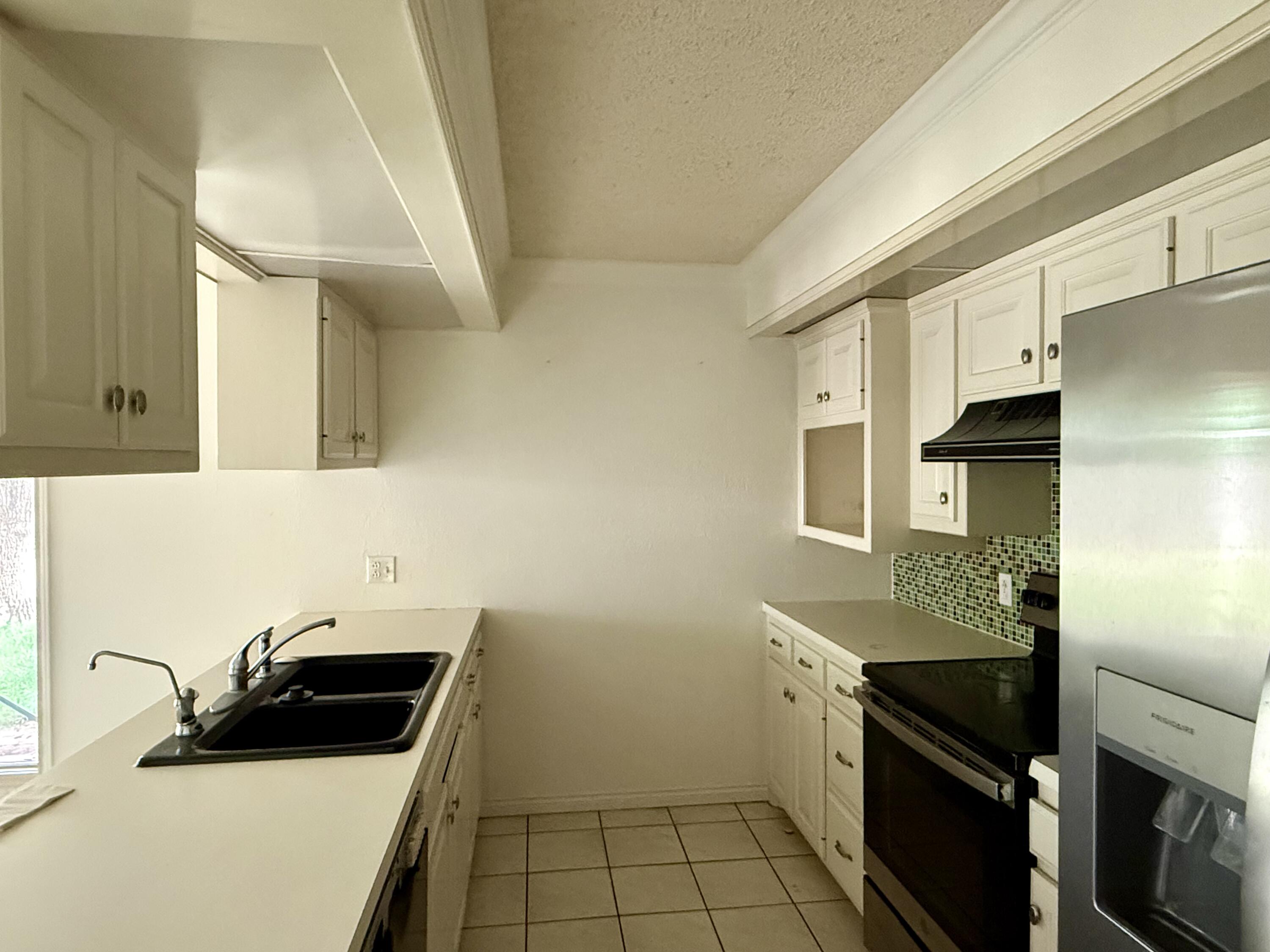 5912 74th Street Lubbock, TX 79424 - Photo 5 of 12 a kitchen with a sink cabinets and stainless steel appliances
