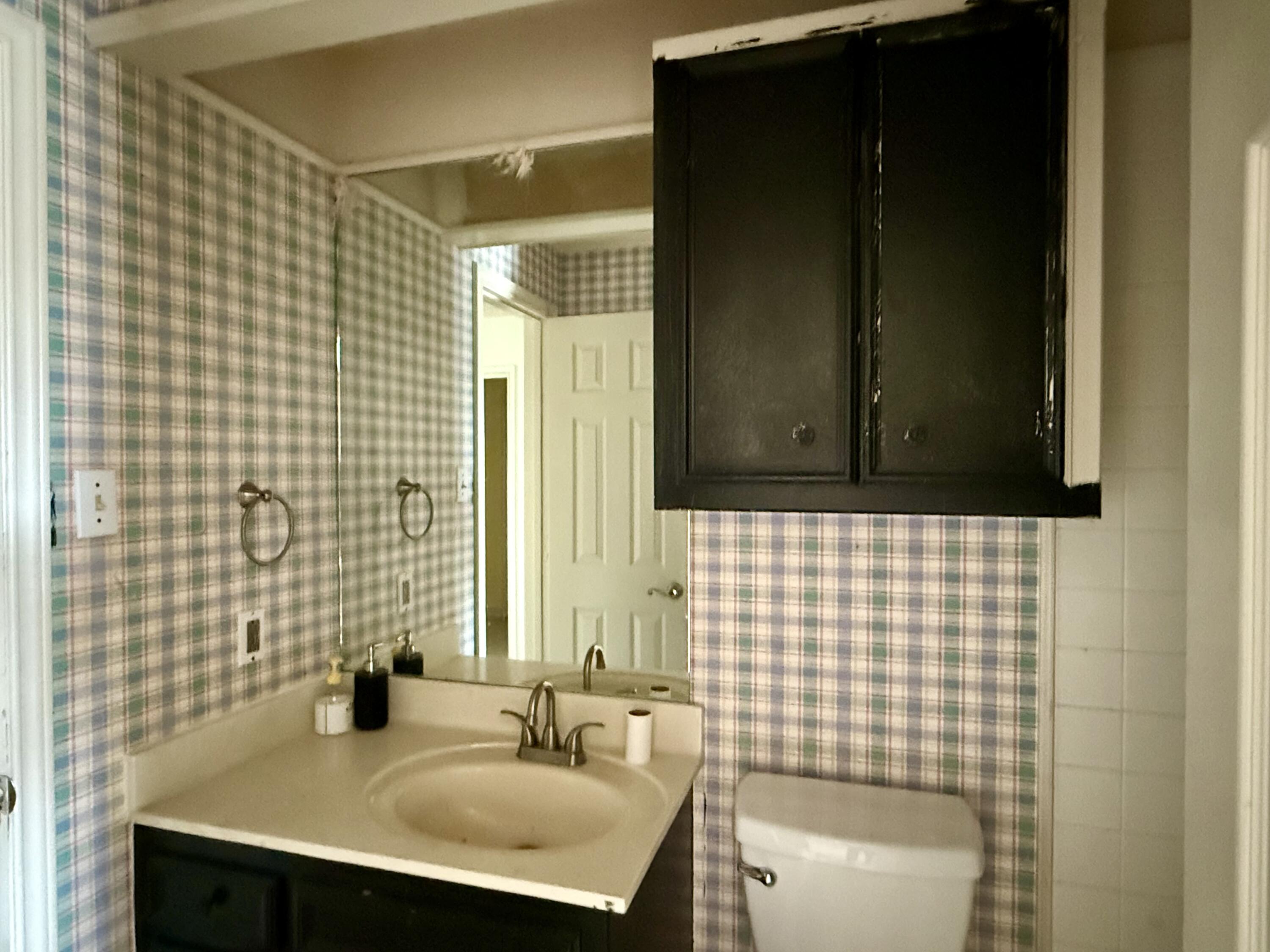 5912 74th Street Lubbock, TX 79424 - Photo 7 of 12 a bathroom with a sink a toilet and mirror
