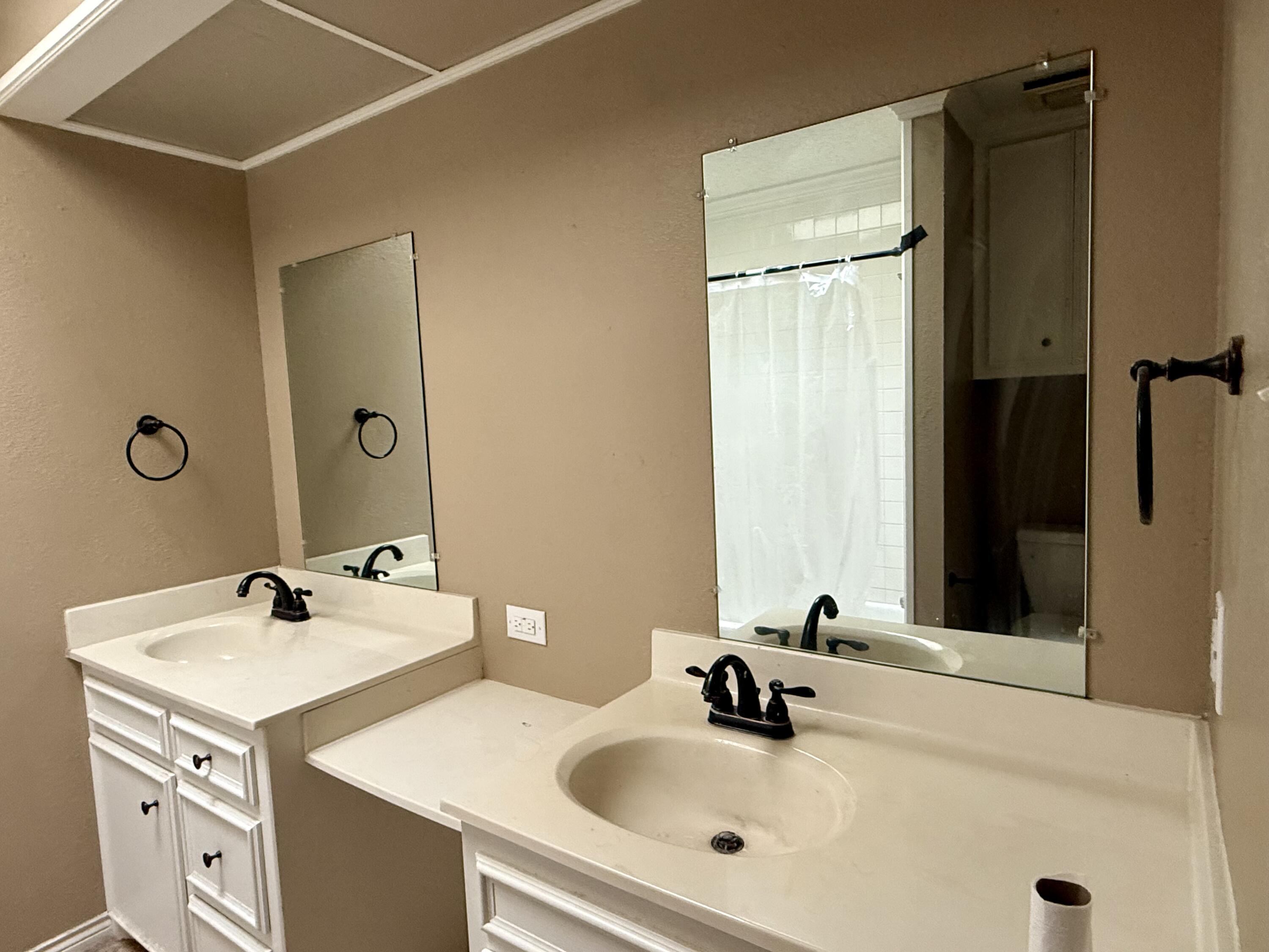 5912 74th Street Lubbock, TX 79424 - Photo 10 of 12 a bathroom with a sink and a mirror